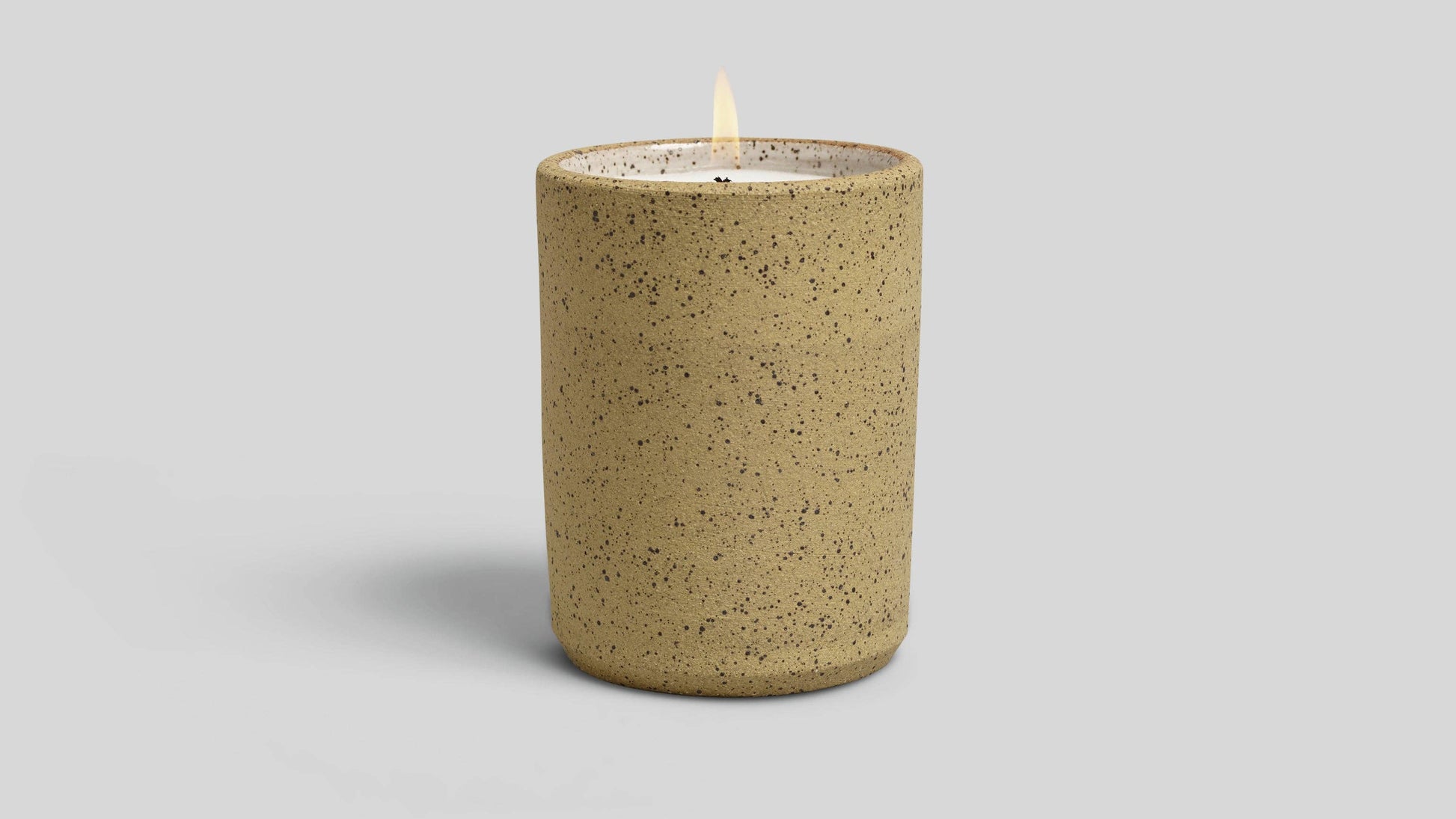 Speckled brown candle on a light gray background