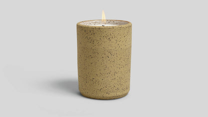 Speckled brown candle on a light gray background