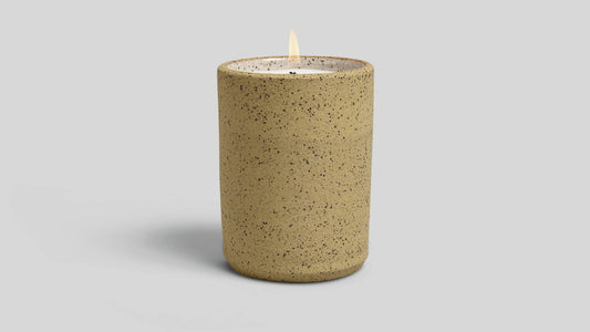 Speckled brown candle on a light gray background
