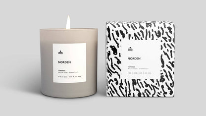 Candle and packaging with 'Norden' branding on a light gray background