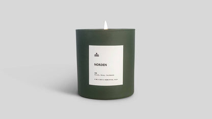 Green candle with a label on a light gray background