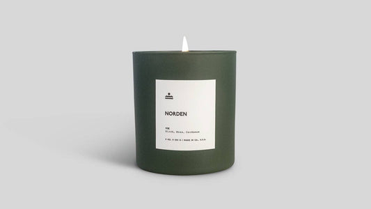 Green candle with a label on a light gray background